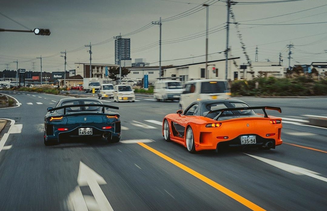 2 Veilside RX7s driving in Japan