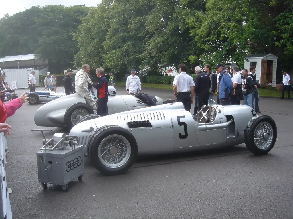 Silver Auto Union and Mercedes-Benz Grand Prix cars of the 1930s in a paddock