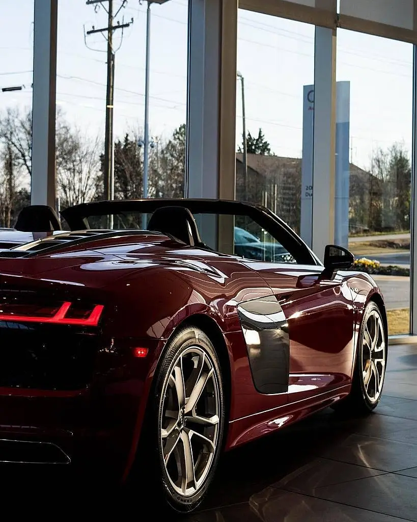 Dark red Audi R8 Spyder in front of a showroom window