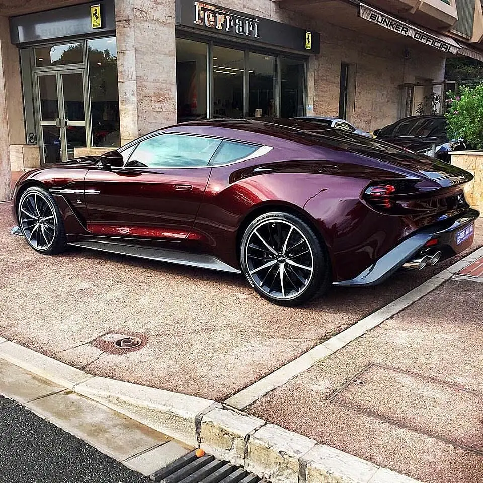 Dark red Aston Martin Vanquish Zagato in front of a Ferrari dealership