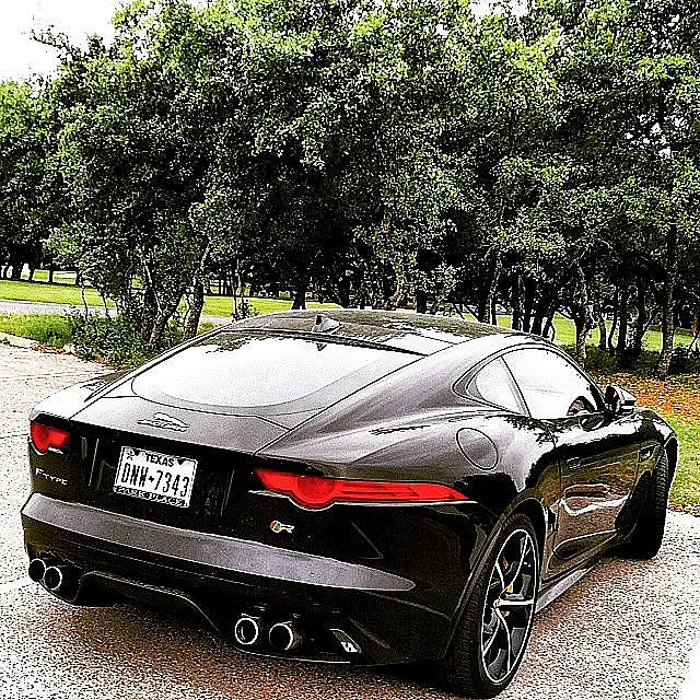 Black Jaguar F-Type from behind on a park road