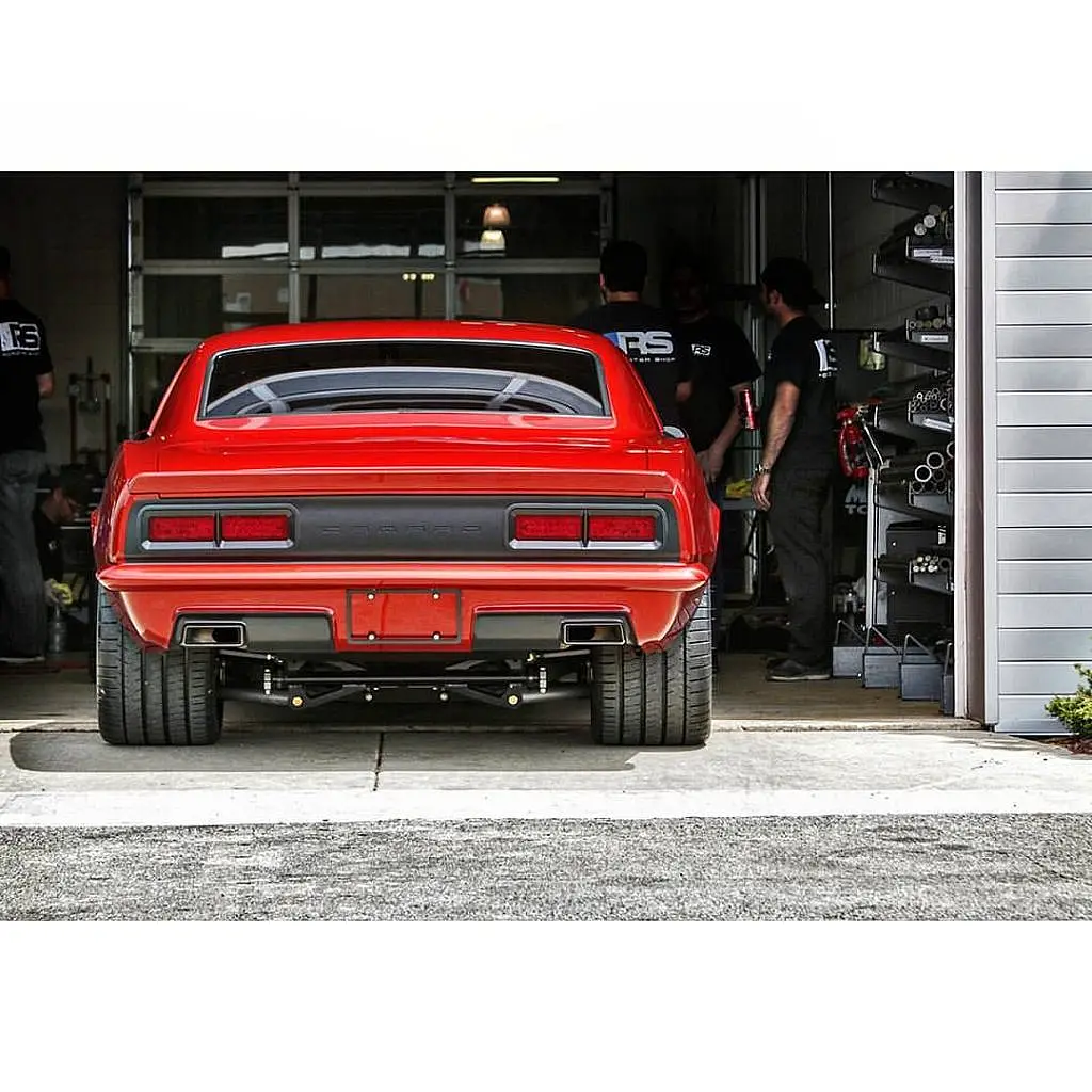 Red Chevrolet Camaro from behind in a garage