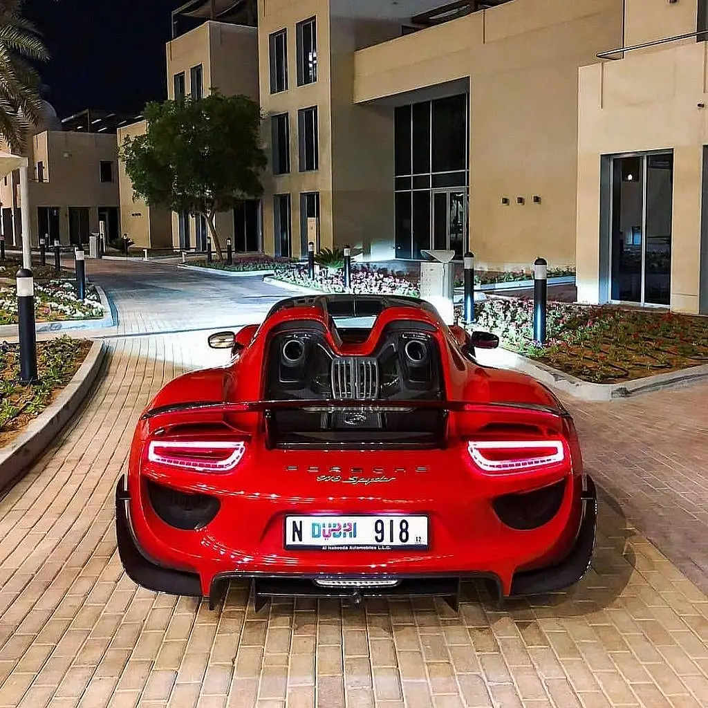 Red Porsche 918 Spyder from behind on a paved street