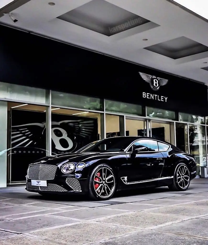 Black Bentley Continental GT in front of a dealership
