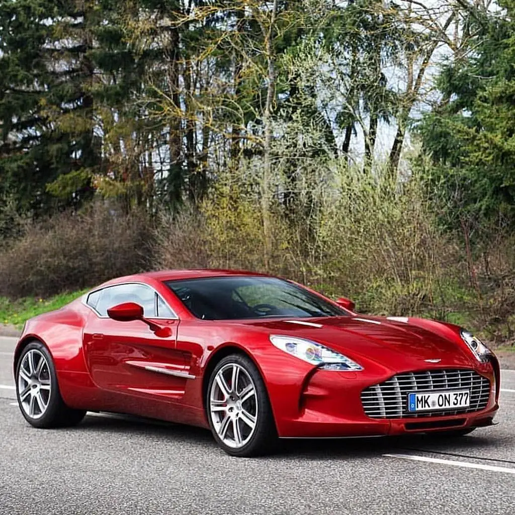 Red Aston Martin One-77 on a forest road