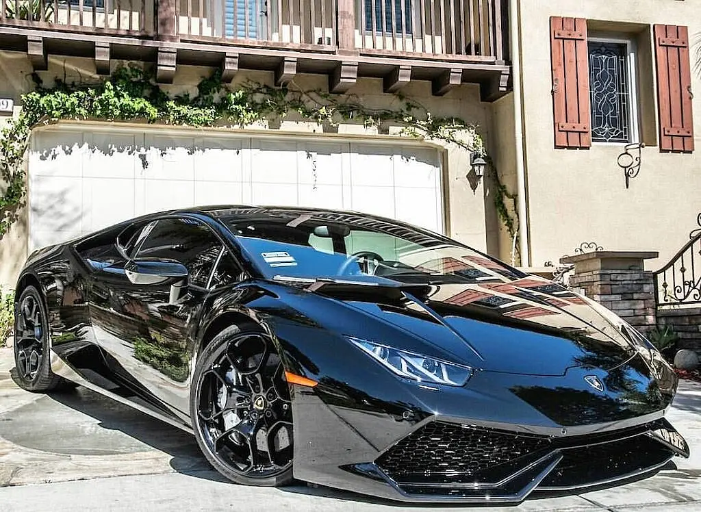 Black Lamborghini Huracán in front of a villa garage