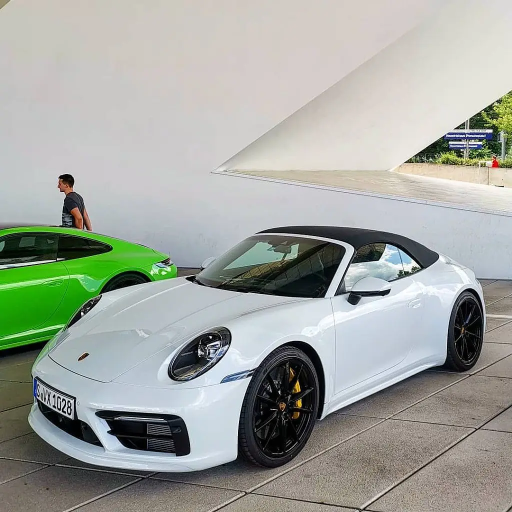 White Porsche 911 Cabriolet next to a green Lamborghini