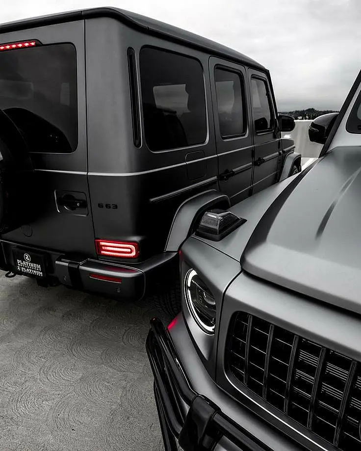 Two black Mercedes G-Class SUVs, rear and front details