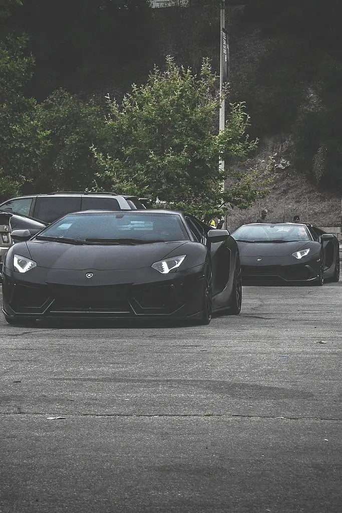 Black Lamborghini Aventador in a car park with another behind