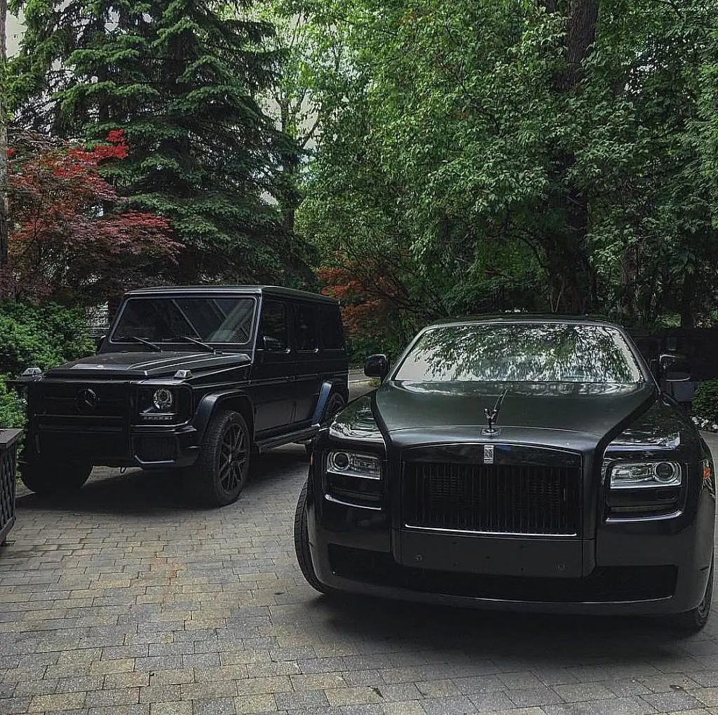 Black Mercedes G-Class and Rolls-Royce Ghost in a courtyard