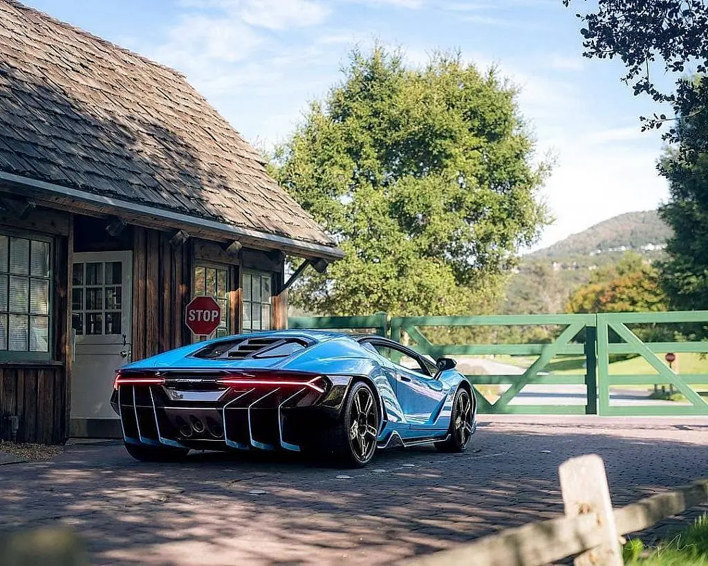 Blue Lamborghini Centenario from behind on a country road