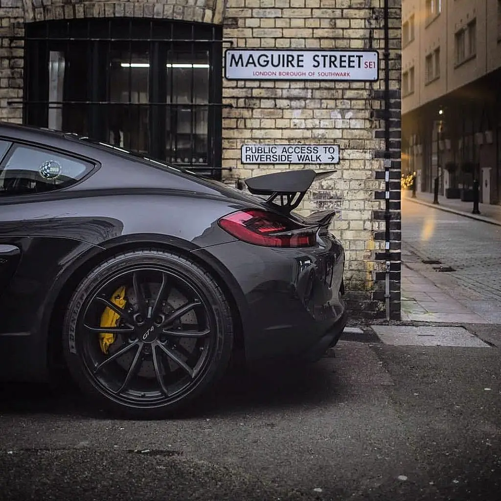 Porsche Cayman GT4 beside a street sign