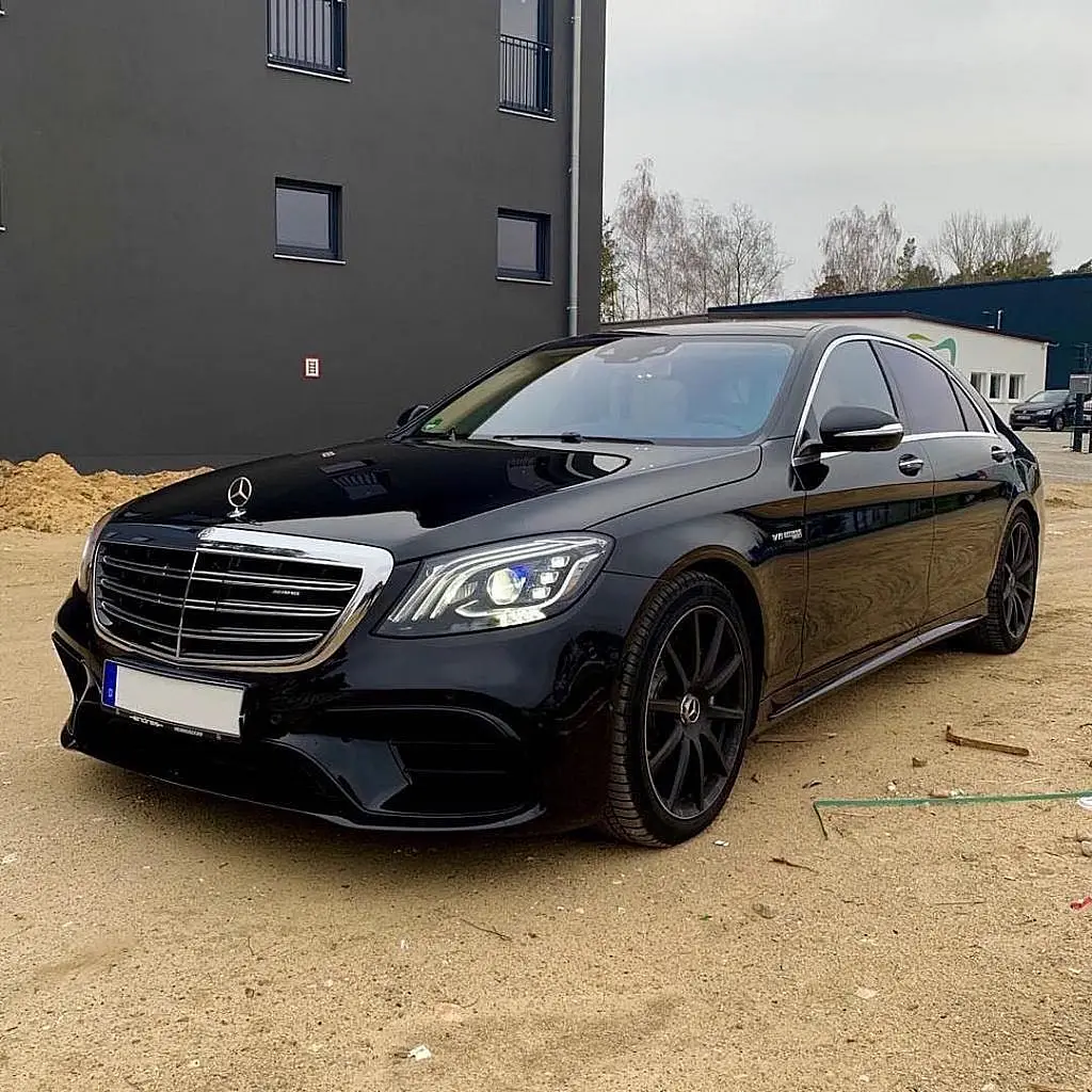 Black Mercedes-Benz S-Class in front of a building site