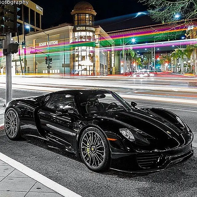 Black Porsche 918 Spyder on a city street at night