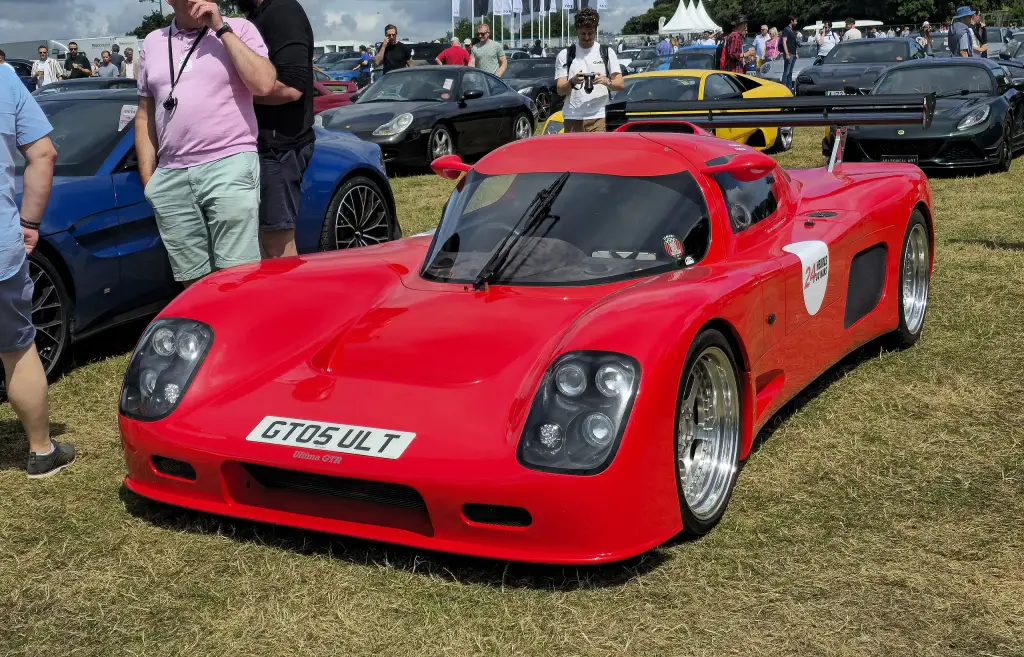 Red Ultima GTR with a tall rear wing on show among other cars