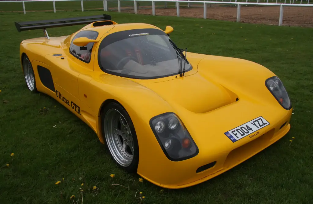 Yellow Ultima GTR with a rear wing, seen from the front left